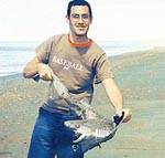 Luciano Zorzoli muestra un ejemplar de gatopardo mediano que luego de ser desenganchado fue devuelto al agua.
