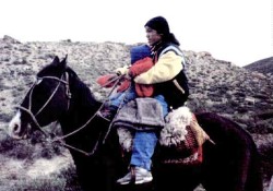 Mujer mapuche, regresando a su comunidad con su hijo.